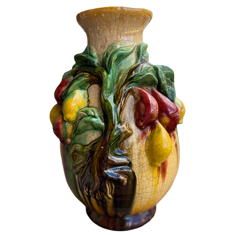 Decorative ceramic vase with fruit and leaf design on a white background