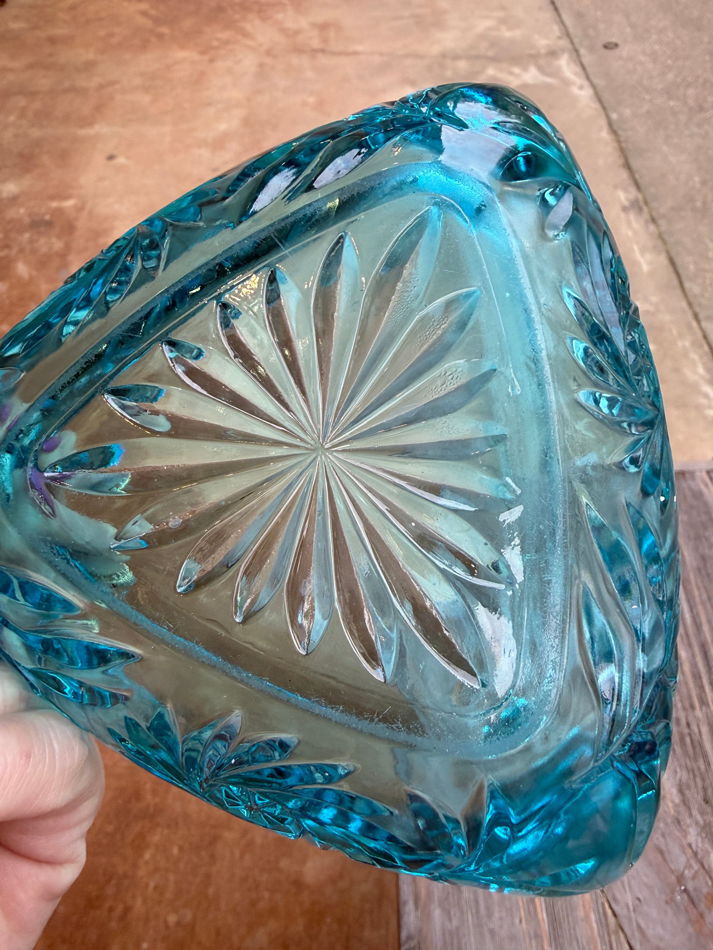 Blue crystal vase with intricate patterns on a wooden surface