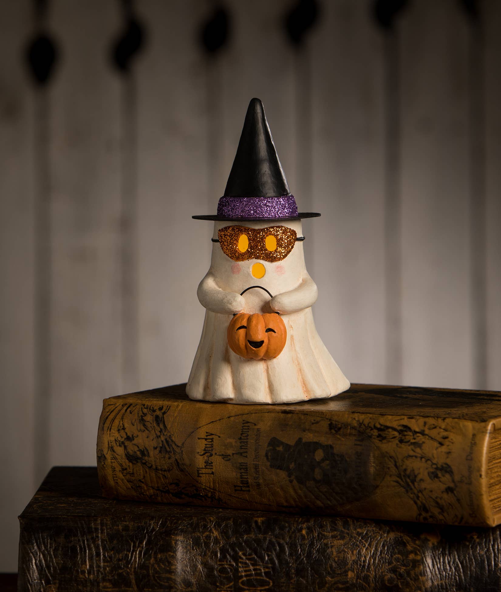 Bethany Lowe Designs Witchy Ghost with Pumpkin Halloween figurine wearing a pointed witch hat and holding an orange pumpkin trick-or-treat bucket.