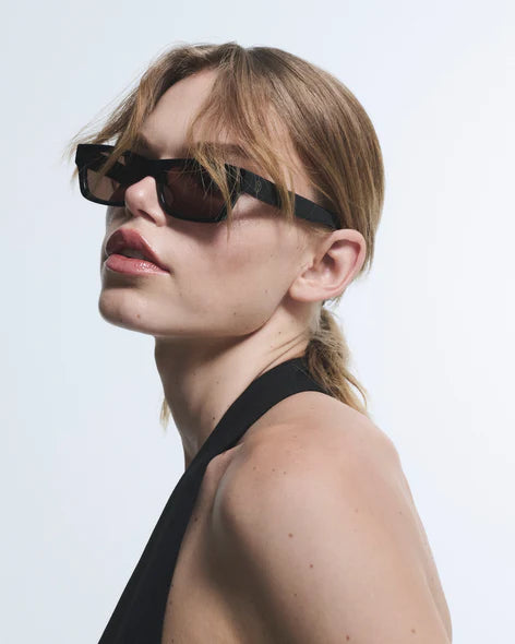 Woman wearing black sunglasses with a plain background
