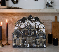 Lighted haunted paper house by Maren Baxter for My Mind's Eye featuring black, ivory, and gold foil details with an illuminated LED interior.