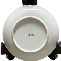 White ceramic dish with 'China' inscription on a black stand against a white background