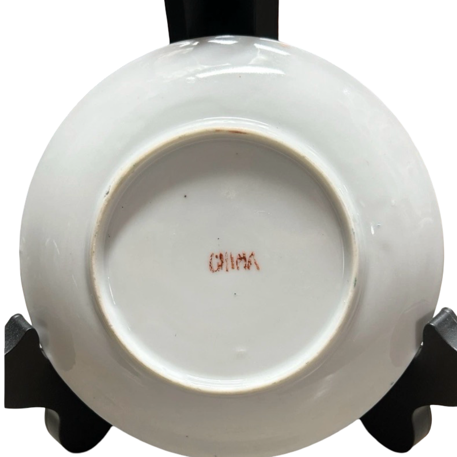 White ceramic dish with 'China' inscription on a black stand against a white background