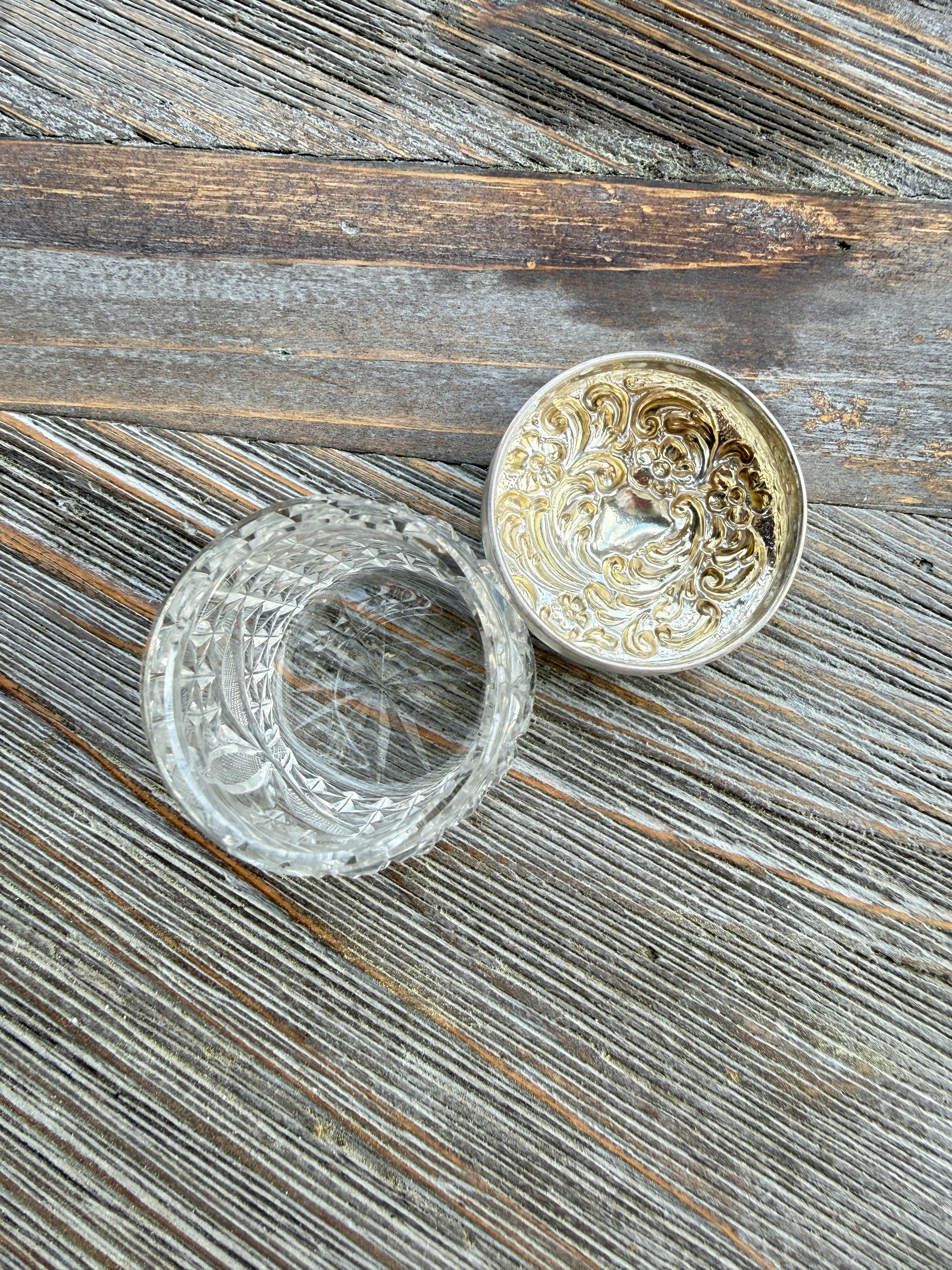 Decorative silver and glass container on a wooden surface