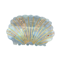 Blue-gray acetate shell-shaped claw clip decorated with sparkling rhinestones.