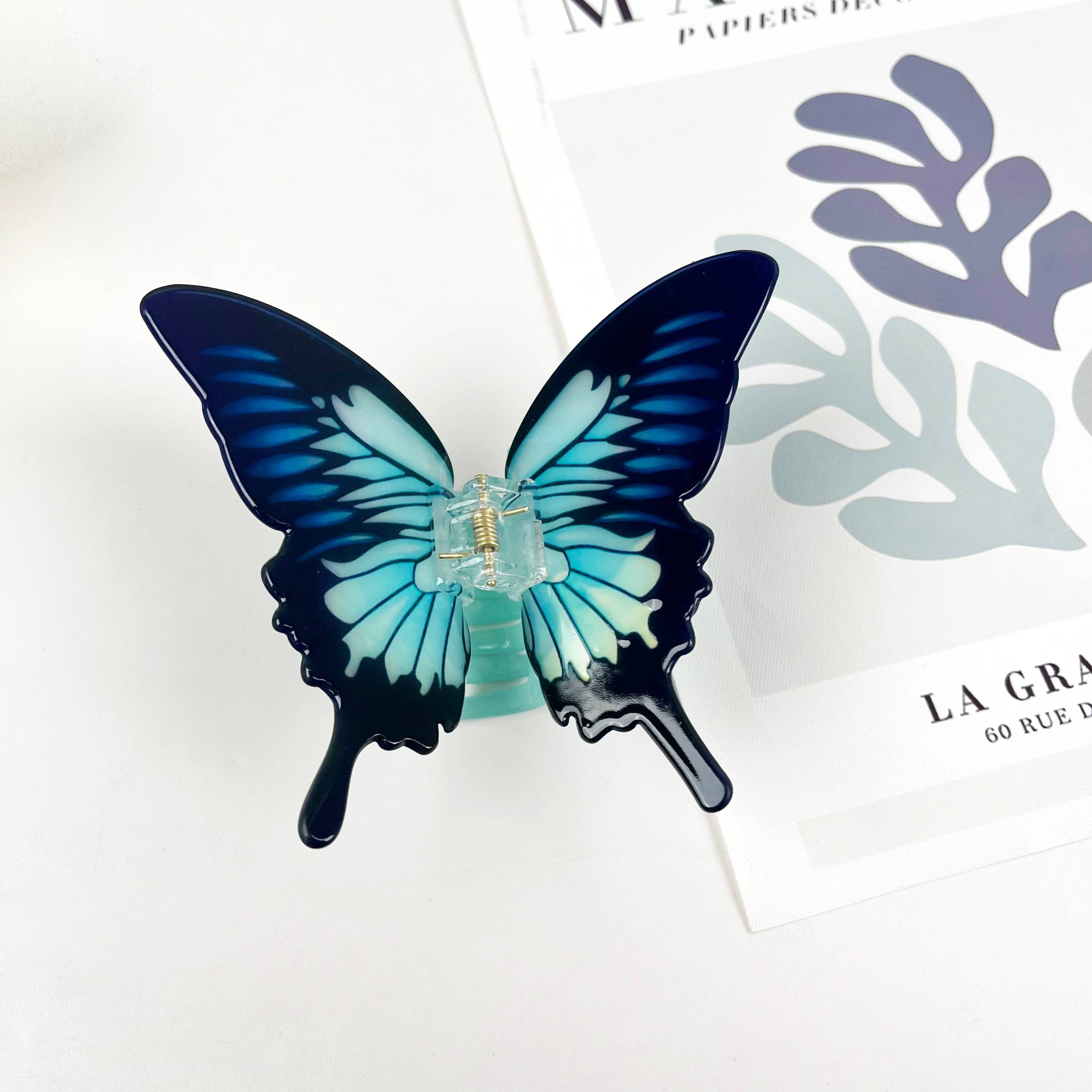 Blue acetate large butterfly-shaped hair claw clip with sculptural wings and a secure claw closure.