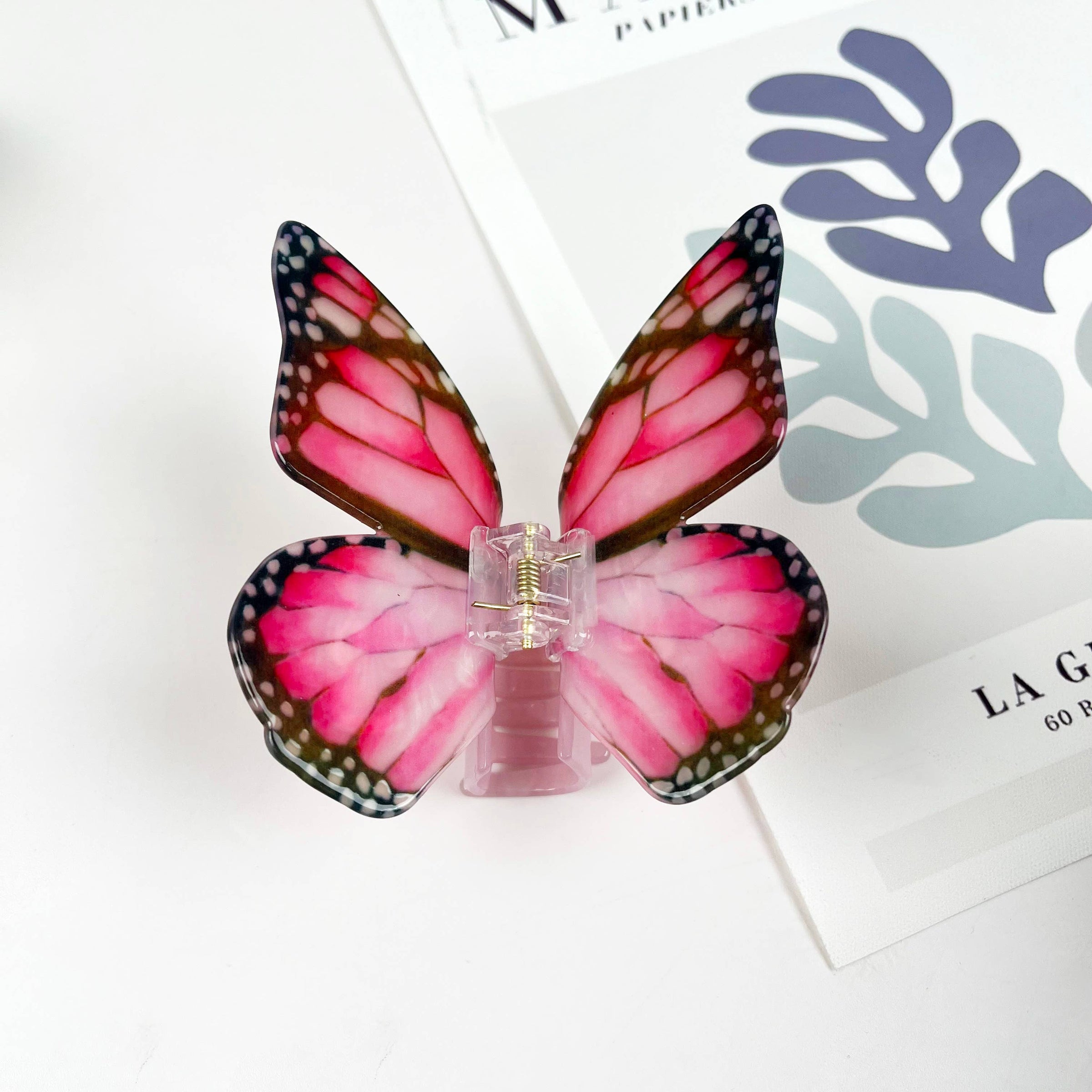 Dark pink acetate large butterfly-shaped hair claw clip with sculptural wings and a secure claw closure.