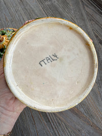 Ceramic dish with 'Raku' branding on a wooden surface
