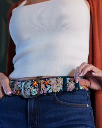 Deep navy wool belt with dimensional lavender, orange, green, cream, and yellow floral embroidery and a lead-free metal buckle.
