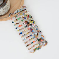 Multicolor acetate wide-tooth hair comb with smooth curved teeth for detangling straight, wavy, and curly hair.