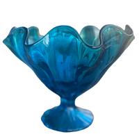 Blue glass bowl with wavy design on a white background