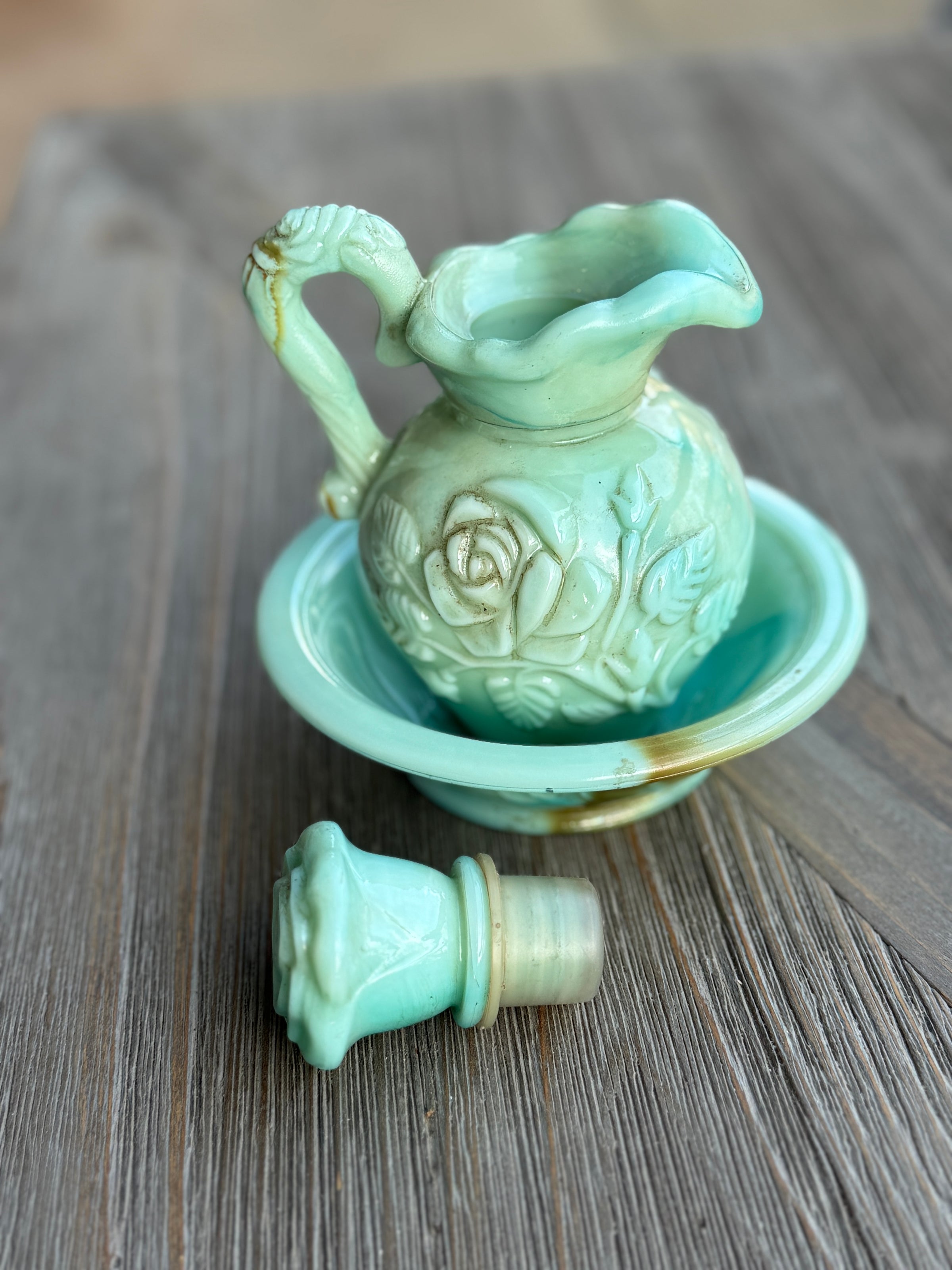 Light green ceramic pitcher with spout on a wooden surface