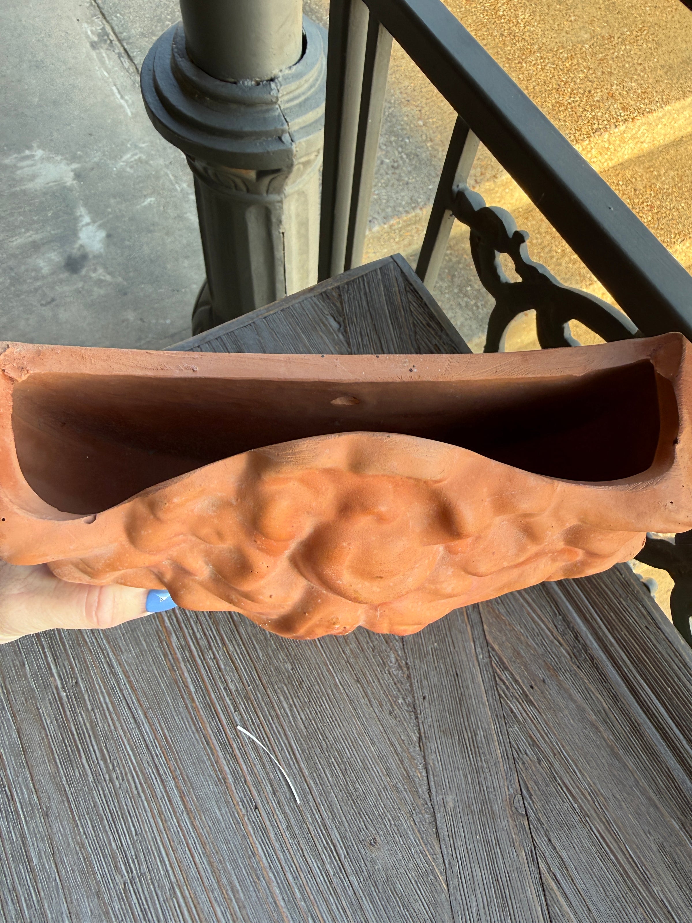 Decorative urn with muscular design on a wooden surface