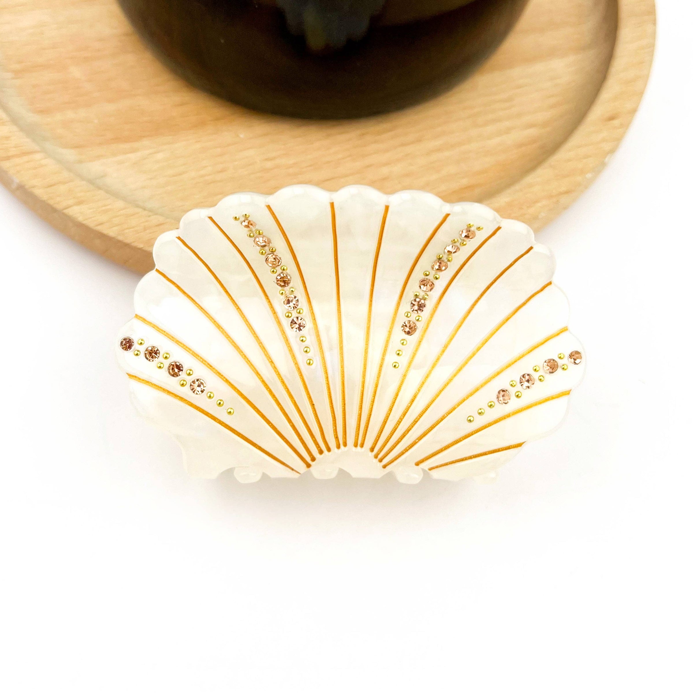 White acetate shell-shaped claw clip decorated with sparkling rhinestones.