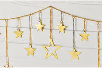 Gold star garland with hanging star cutouts on a chain, displayed against a light gray paneled background.