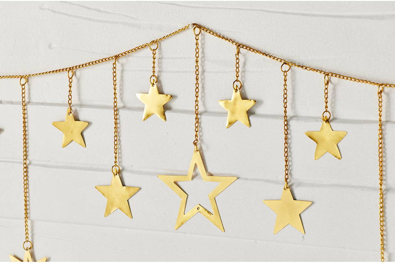 Gold star garland with hanging star cutouts on a chain, displayed against a light gray paneled background.