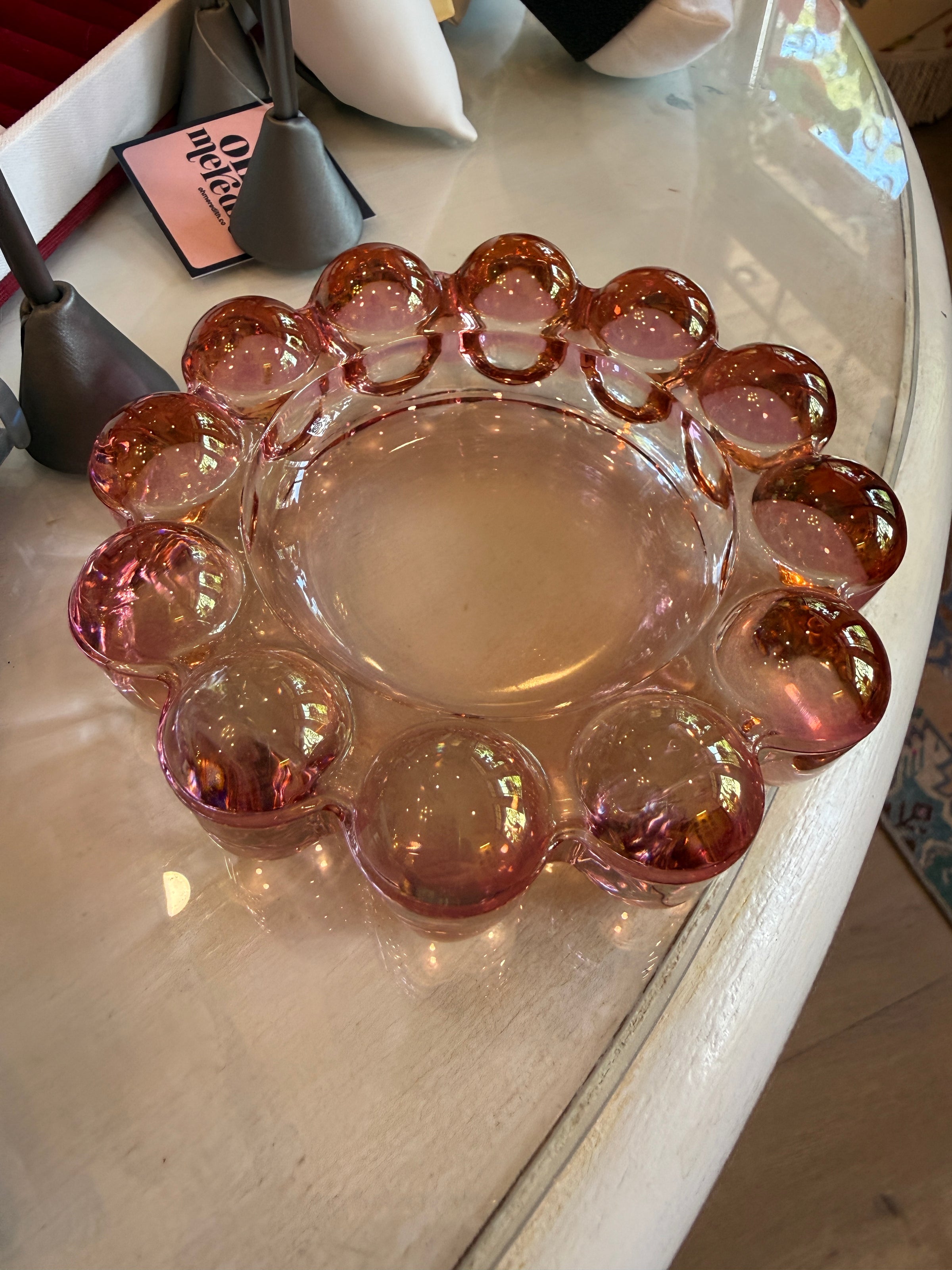 A vintage pink glass party platter with a scalloped rim, displayed on a white table.