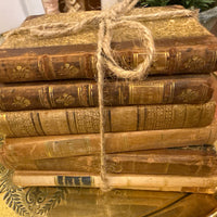 Stack of old books tied with twine on a decorative surface
