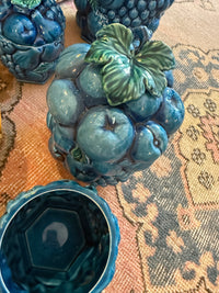 Decorative ceramic fruit bowl with blue glaze on a textured surface