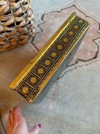 Decorative box with intricate patterns on a textured surface