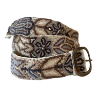 Monochromatic cream embroidered wool belt with taupe, brown, charcoal, and neutral floral stitching and a lead-free metal buckle.