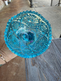 Decorative blue glass bowl on a wooden surface outdoors