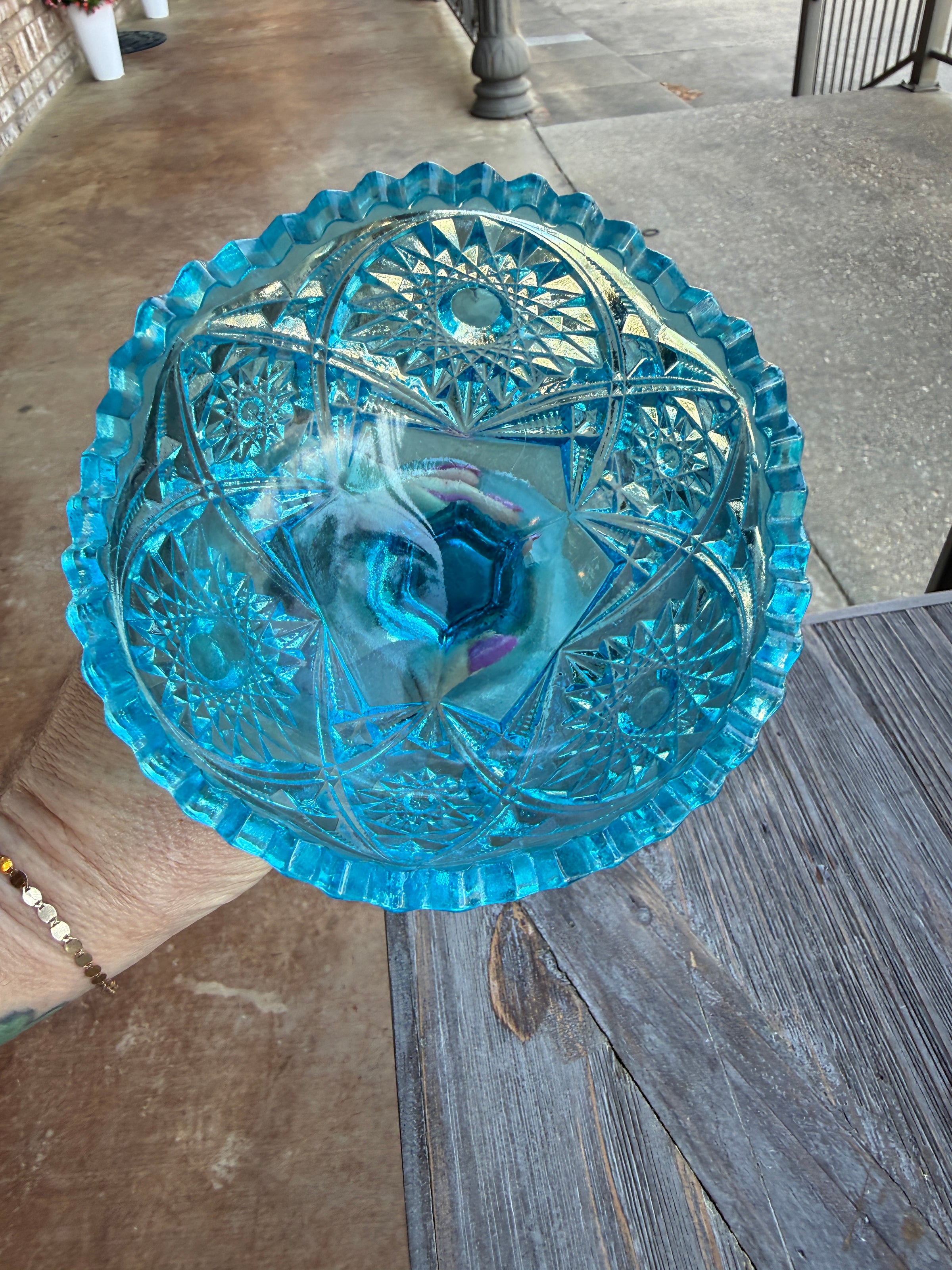Decorative blue glass bowl on a wooden surface outdoors