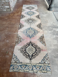 One-of-a-kind vintage wool runner rug with faded blush pink, dusty blue, cream and charcoal medallion pattern, approximately 2'11" x 12'3".