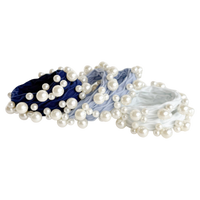 Set of pearl hair ties in blue, gray, and white on a white background