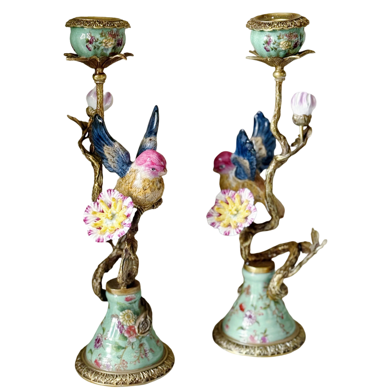 Decorative candle holders with floral designs and bird figurines on a white background