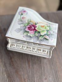 Decorative jewelry box with floral design on a wooden surface