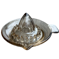 Clear glass citrus juicer on a white background