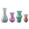 Four glass vases of different designs and colors on a white background
