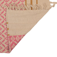 Close-up of a folded fabric with pink and beige pattern on a white background