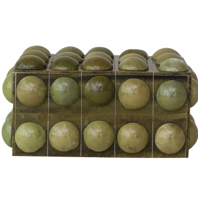 Green spherical objects in a clear plastic packaging on a white background