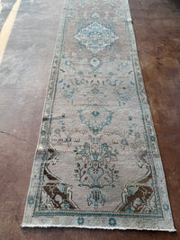 One-of-a-kind vintage Persian runner rug measuring approximately 2'11" x 12'5" with a faded dusty rose ground, blue and turquoise medallion motifs, ivory border and timeworn details.