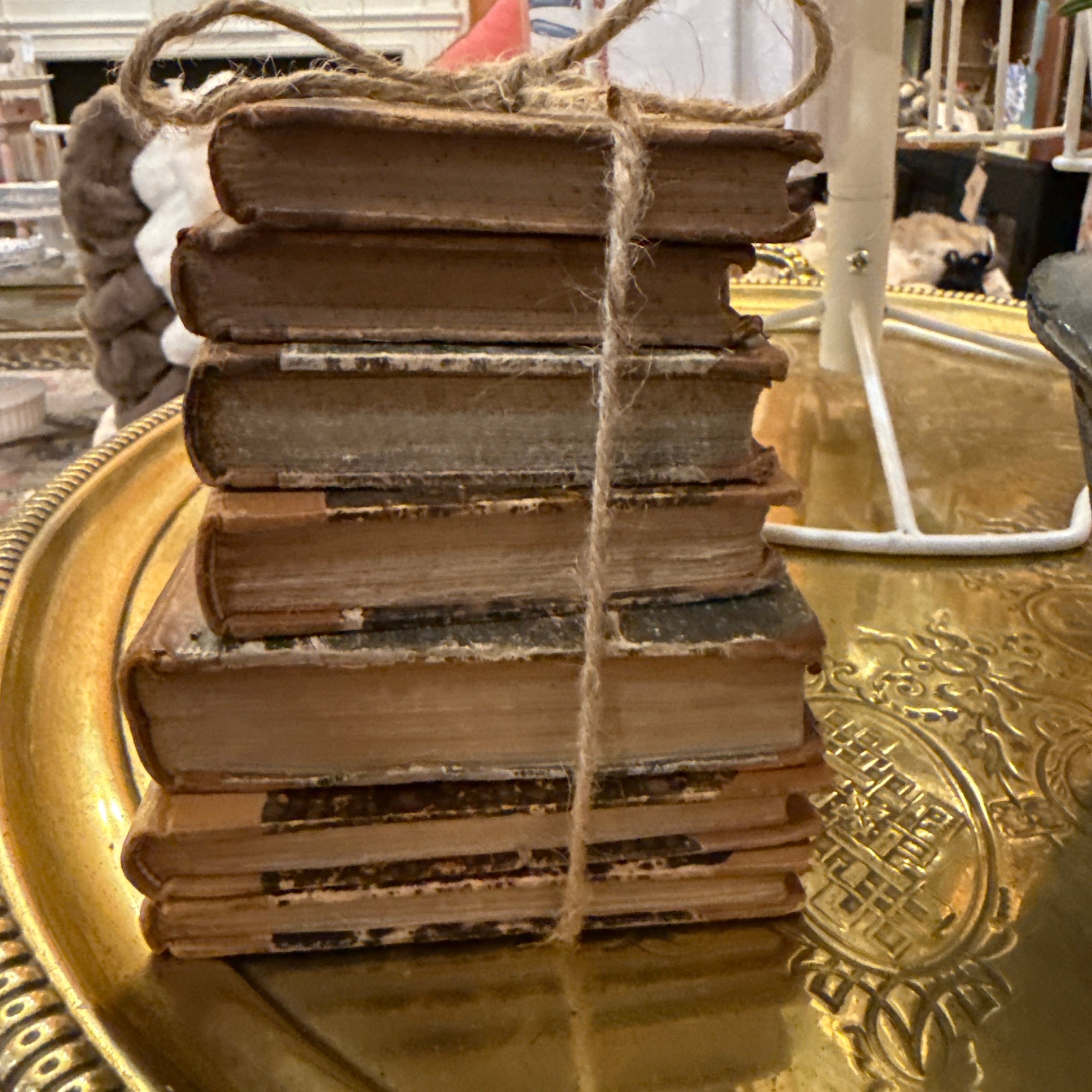 Decorative item with a gold circular design and brown ribbons in a store setting
