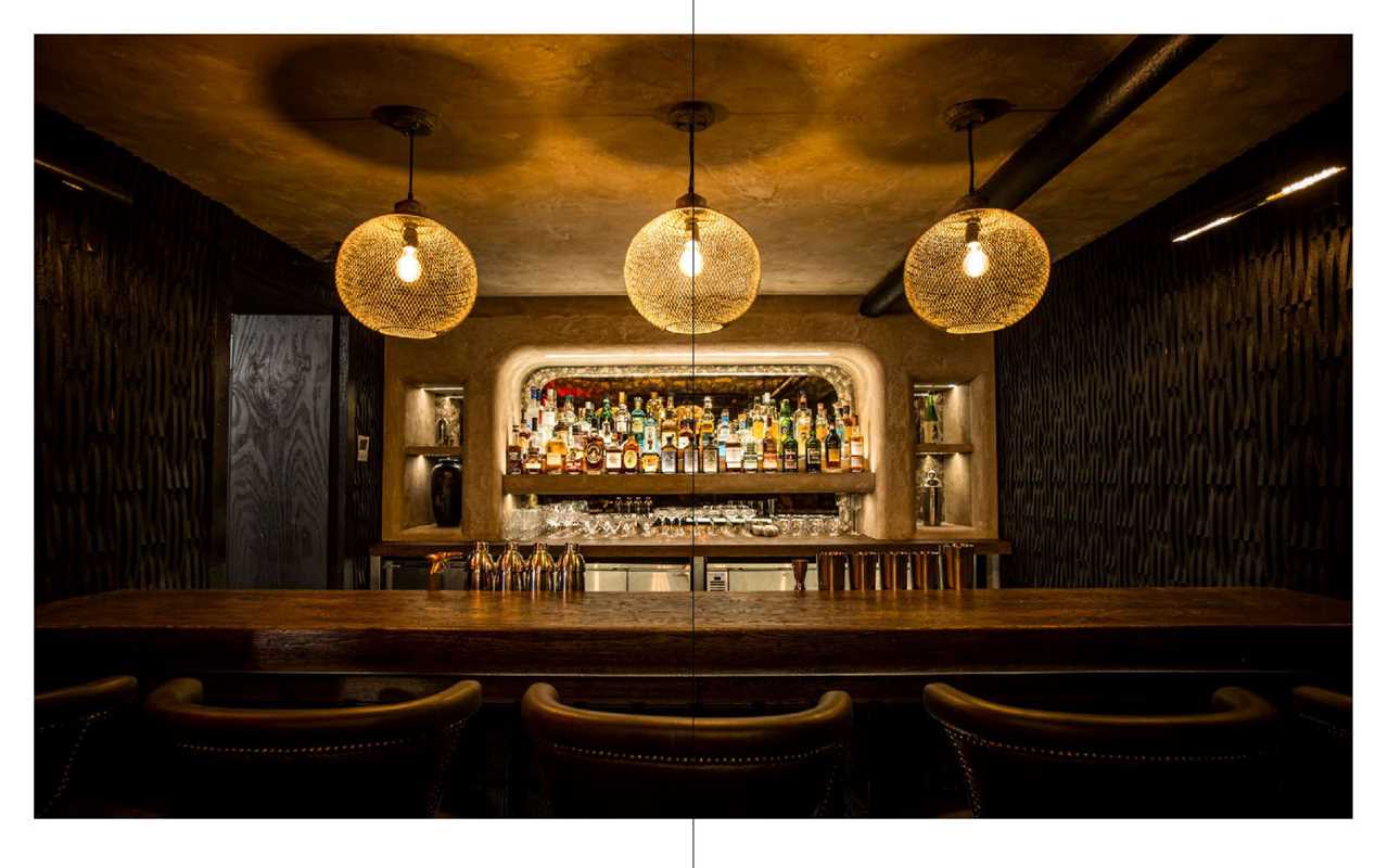 Bar interior with shelves of bottles and hanging lights