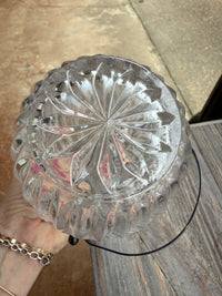 Clear glass bowl with decorative pattern held by a person on a wooden surface