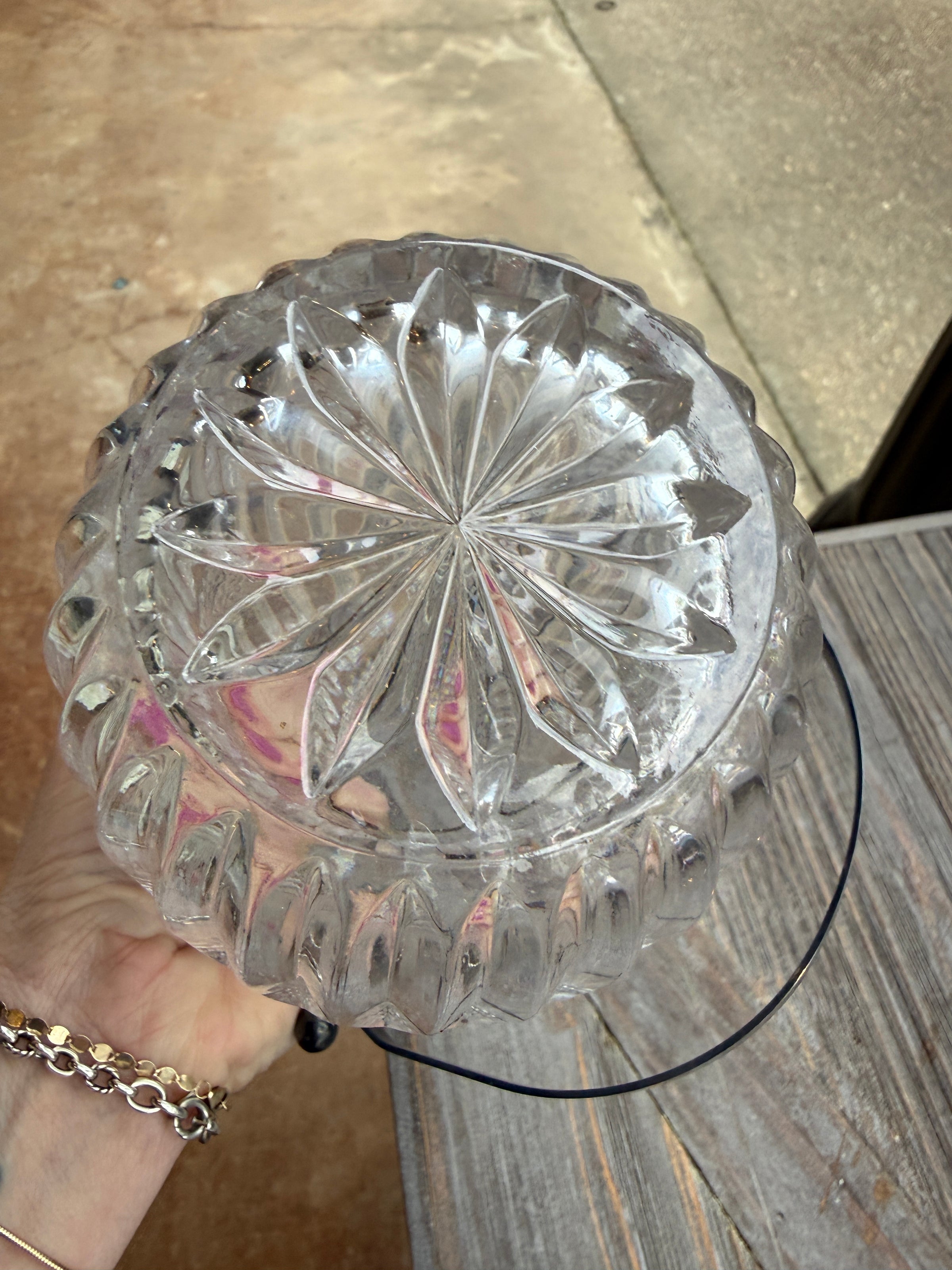 Clear glass bowl with decorative pattern held by a person on a wooden surface