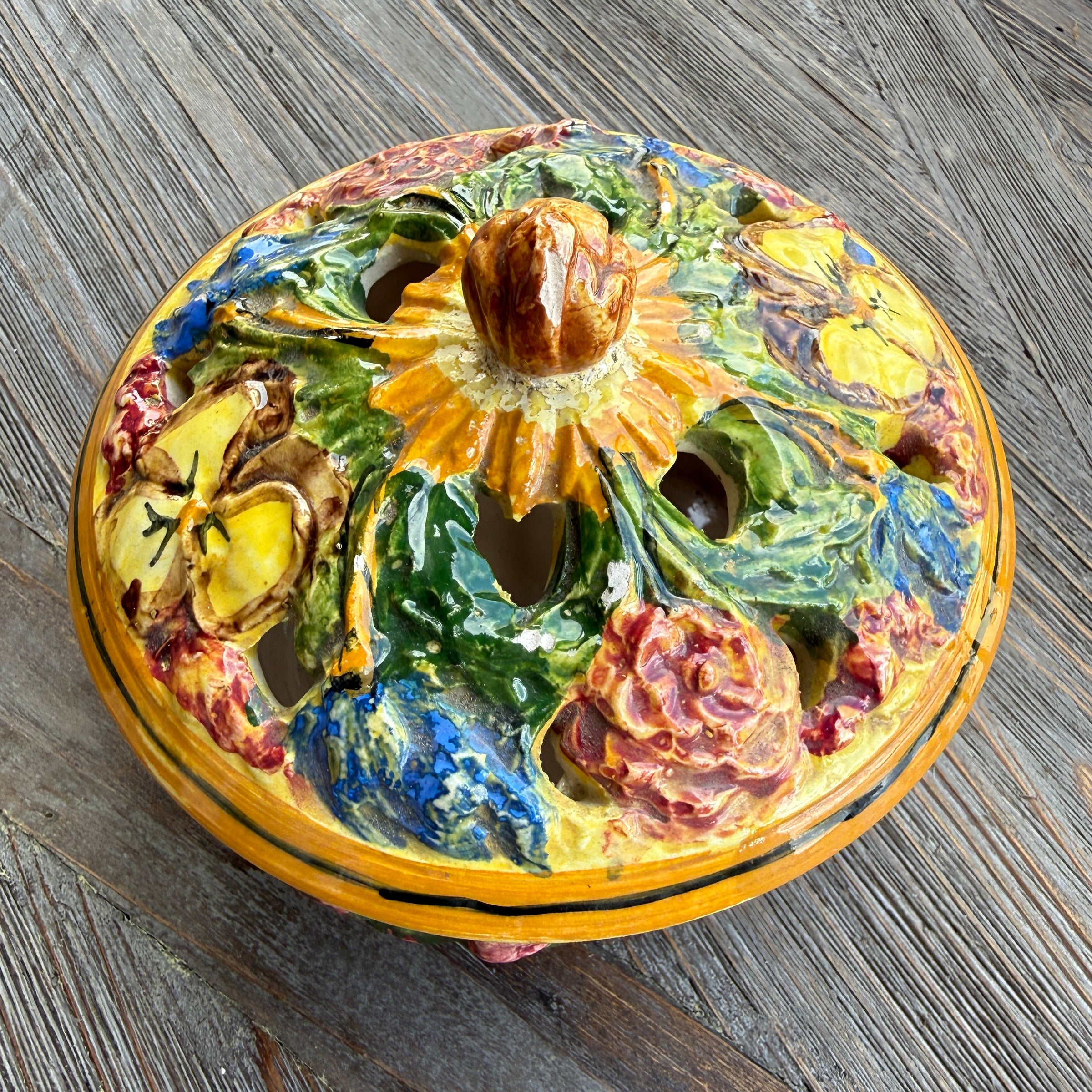 Decorative ceramic knob with floral design on a wooden surface