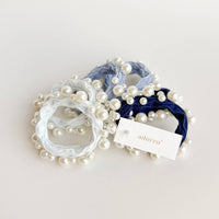 Set of pearl-adorned hair ties with a visible 'adorro' tag on a light background