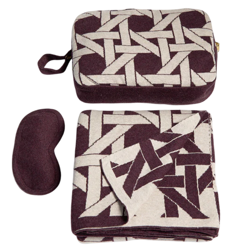 Set of travel items including a patterned eye mask and pouch on a white background