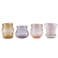 Set of four glass candle holders in different colors on a white background