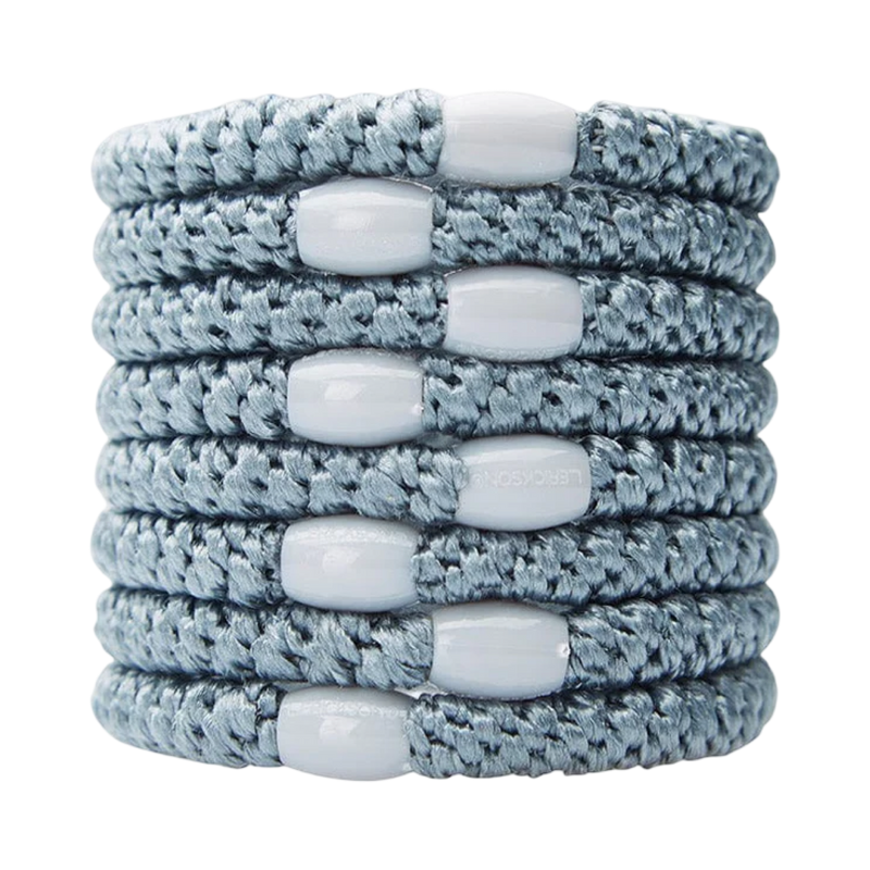 Stack of gray braided bracelets with white beads on a white background