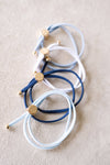 Set of blue and white bracelets with gold accents on a beige surface