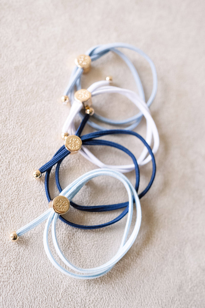 Set of blue and white bracelets with gold accents on a beige surface