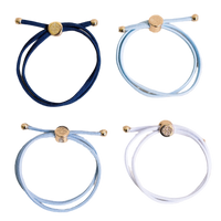 Four bracelets in blue, white, and gold on a white background