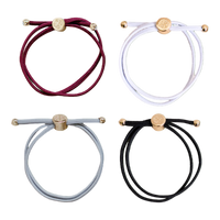 Four bracelets in red, white, gray, and black with gold accents on a white background