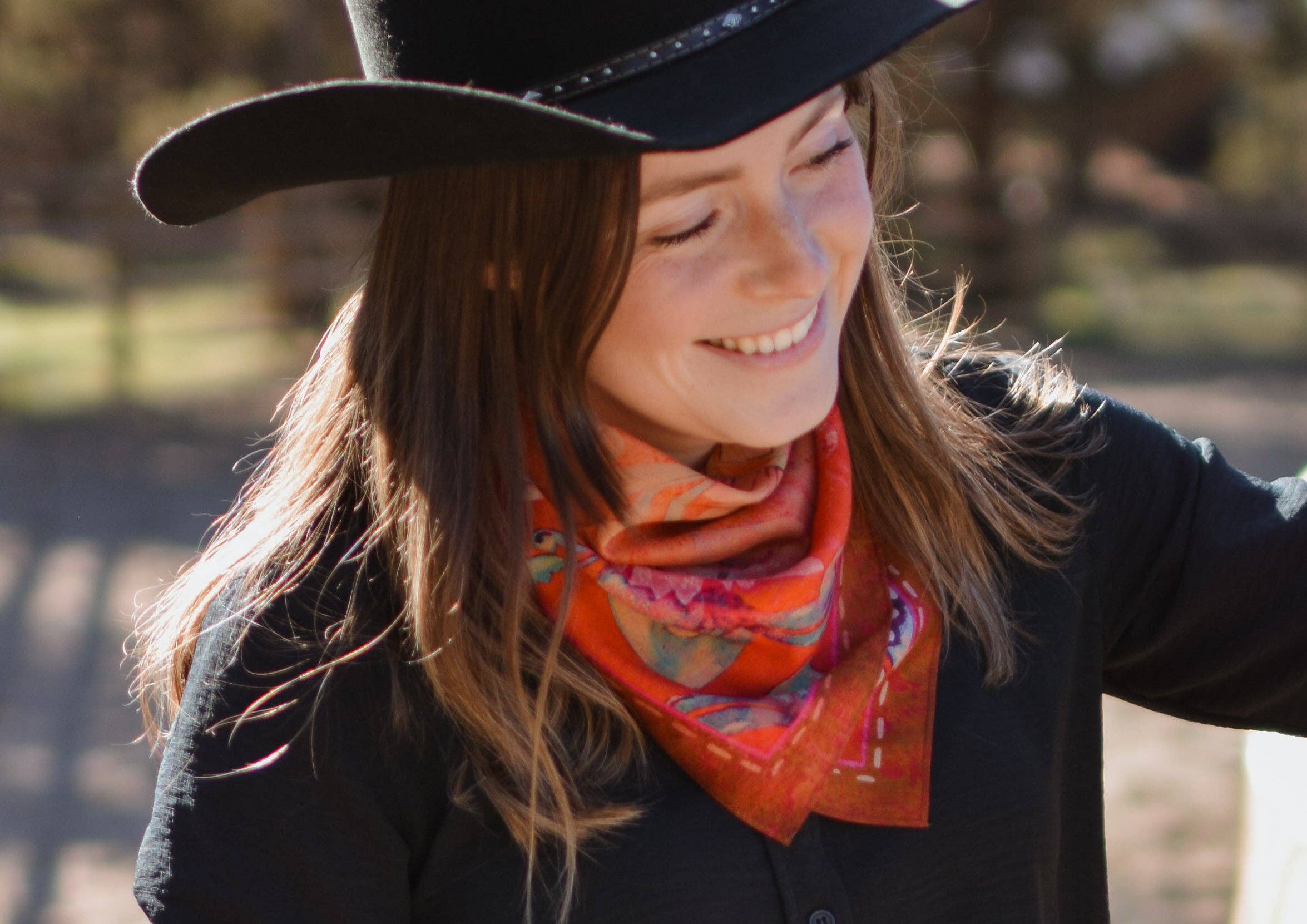 Woman wearing a black hat and colorful scarf outdoors